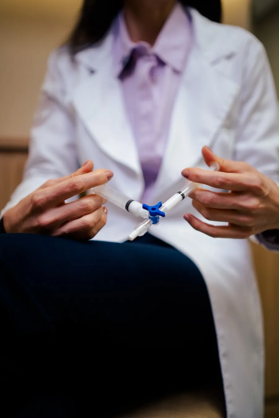 Médica preparando a espuma esclerosante em duas seringas conectadas por uma torneira de três vias